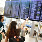 aeropuerto, viajeros miran vuelos