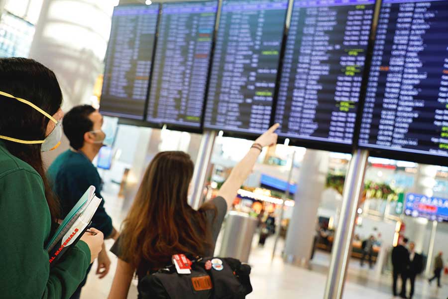 aeropuerto, viajeros miran vuelos