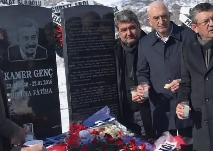 Özel drinking alcohol in a cemetery