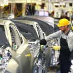 workers assembling cars in a car factory