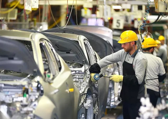 workers assembling cars in a car factory
