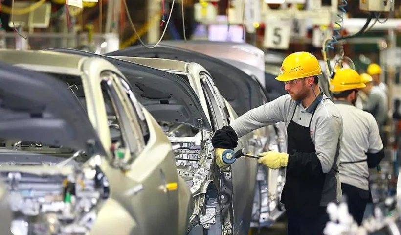 workers assembling cars in a car factory