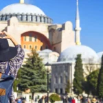Turismo: un turista contempla Santa Sofía en Estambul haciendo el gesto del corazón con la mano
