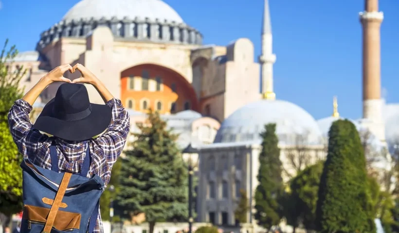 Turismo: un turista contempla Santa Sofía en Estambul haciendo el gesto del corazón con la mano