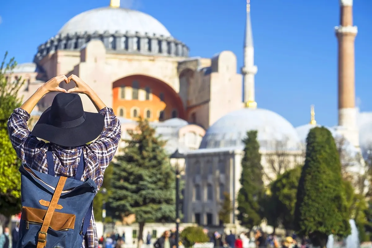 Turismo: un turista contempla Santa Sofía en Estambul haciendo el gesto del corazón con la mano