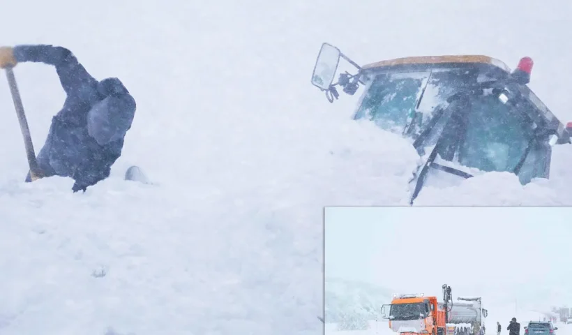 una persona trata de desenterrar con una pala una excavadora sepultada durante un alud de nieve en medio de las intensas nevadas en Turquía