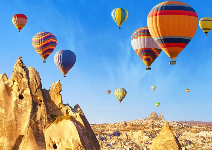 multi-coloured hot-air balloons flying over the fairy chimney landscape of Cappadocia