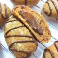 several buns made with flour and cocoa and decorated, one of them split and showing its chocolate filling inside