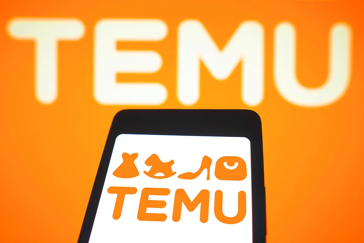 imagen de un teléfono móvil mostrando el logo de Temu, con el nombre de Temu también al fondo