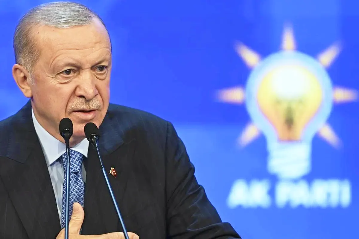 Erdoğan speaking next to the logo of his party, the AKP.
