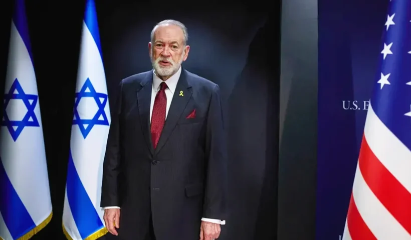 el embajador estadounidense Mike Huckabee junto a las banderas de Israel y Estados Unidos