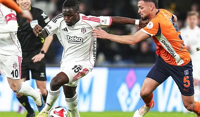jugadores del Beşiktaş y el Başakşehir luchan por el balón en el terreno de juego