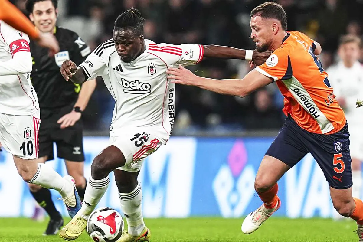 jugadores del Beşiktaş y el Başakşehir luchan por el balón en el terreno de juego