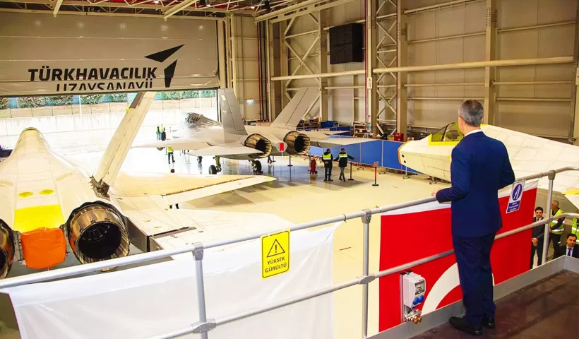 un responsable turco contempla desde lo alto de un hangar tres prototipos del caza de combate turco KAAN