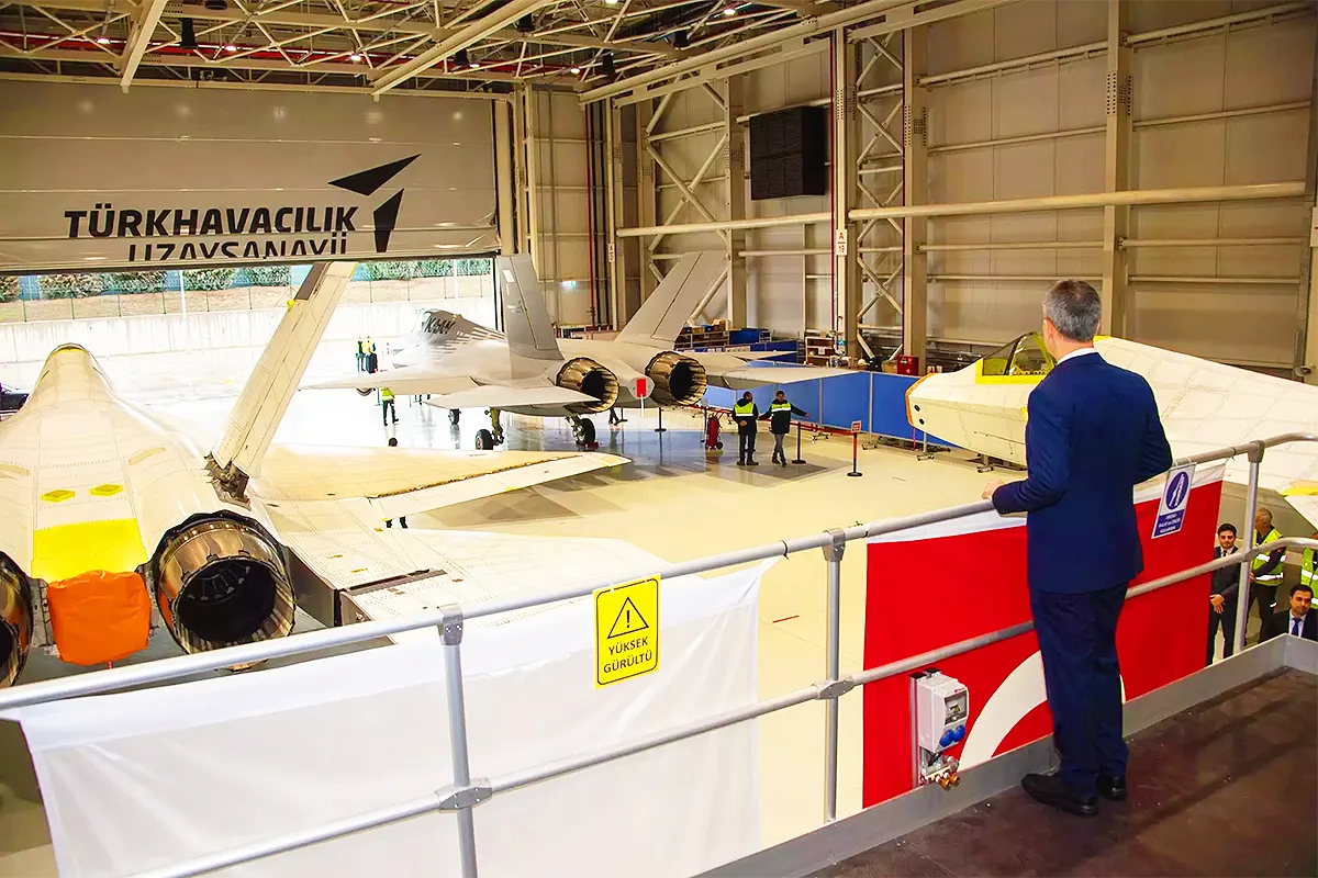 un responsable turco contempla desde lo alto de un hangar tres prototipos del caza de combate turco KAAN
