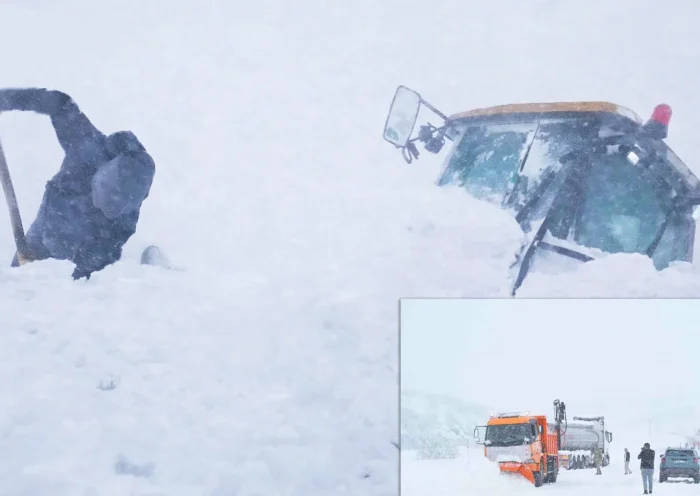A person tries to shovel out an excavator buried in a snow avalanche during heavy snowfall in Turkey.