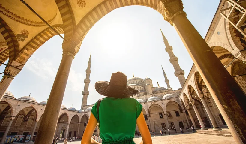 A tourist entering the courtyard of a large mosque in Istanbul.