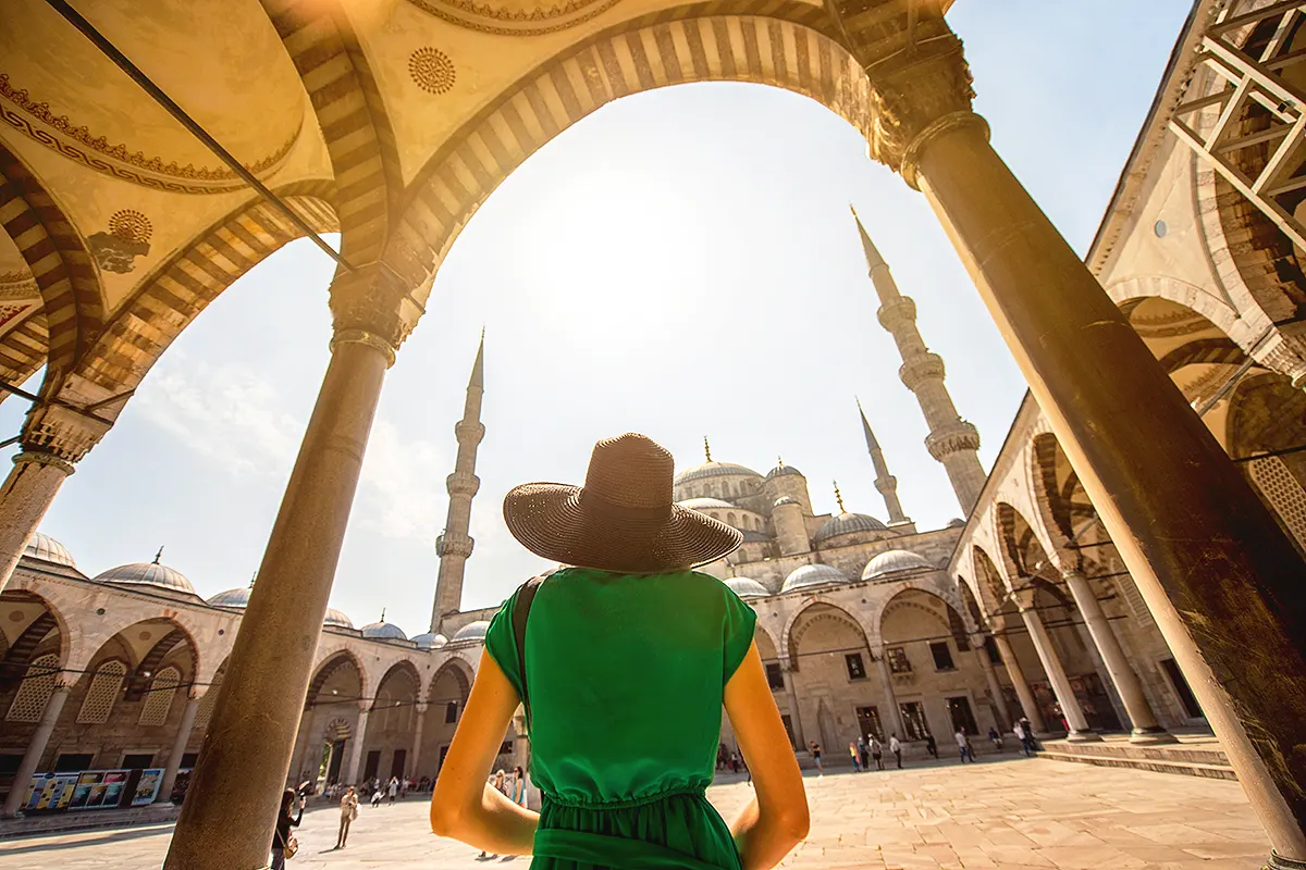 A tourist entering the courtyard of a large mosque in Istanbul.