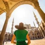 una turista entrando en el patio de una gran mezquita en Estambul