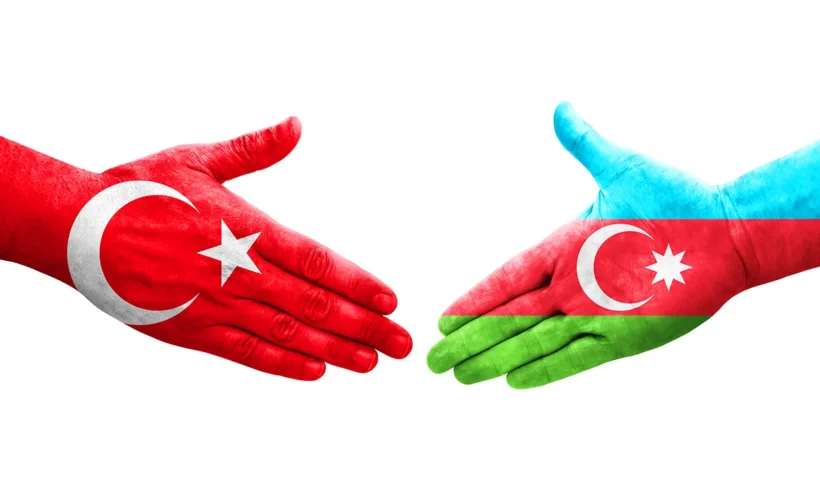 a hand painted with the flag of Turkey and a hand painted with the flag of Azerbaijan shake hands