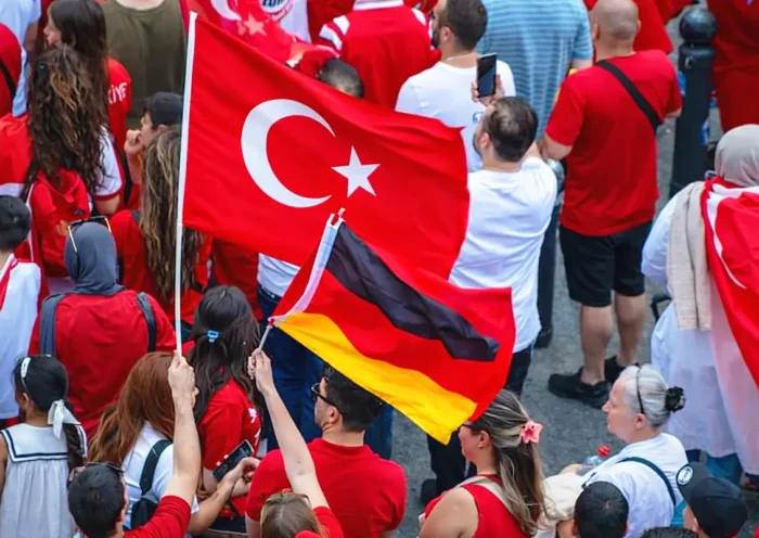A group of people of Turkish origin display Turkish T-shirts and flags as well as a German flag.