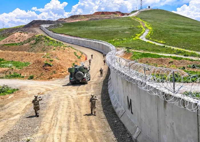Turkish soldiers patrol along the border fence separating Turkey and Iran.