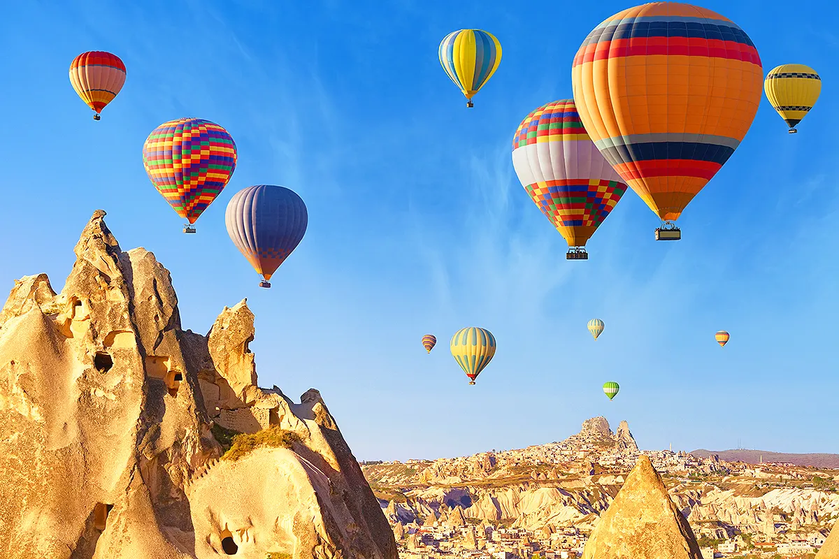 globos aerostáticos de múltiples colores sobrevolando el paisaje de chimeneas de hadas de la Capadocia