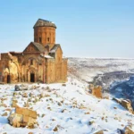 The ancient church of St Gregory in the ruins of Ani, surrounded by snow and next to a ravine on the border between Turkey and Armenia.