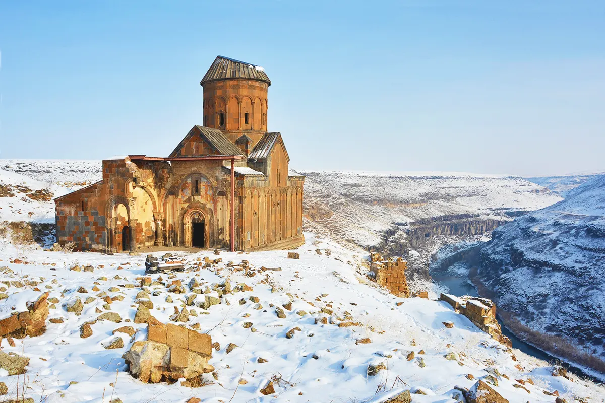 The ancient church of St Gregory in the ruins of Ani, surrounded by snow and next to a ravine on the border between Turkey and Armenia.