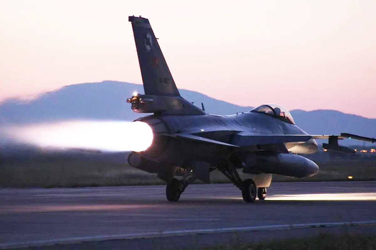 un avión de combate F-16 del ejército turco despegando en el crepúsculo con su motor a reacción a plena potencia