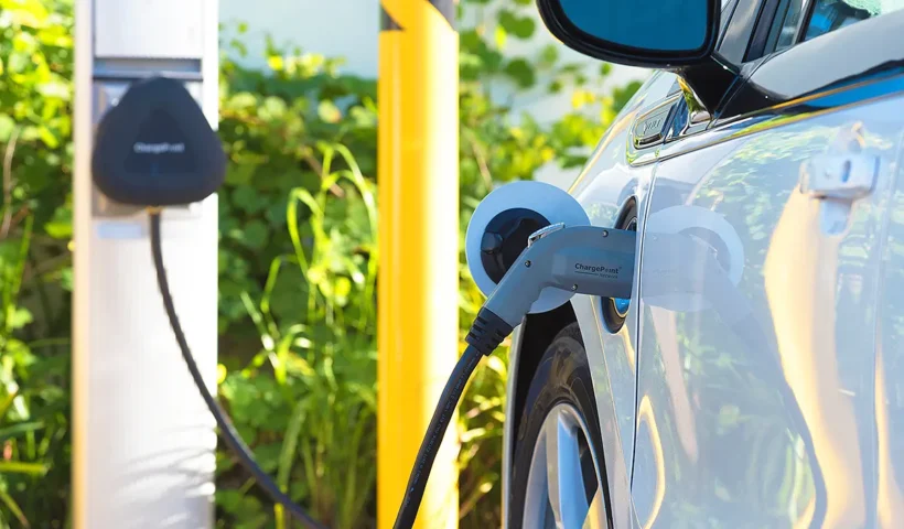 a white electric car connected to a charger on the street