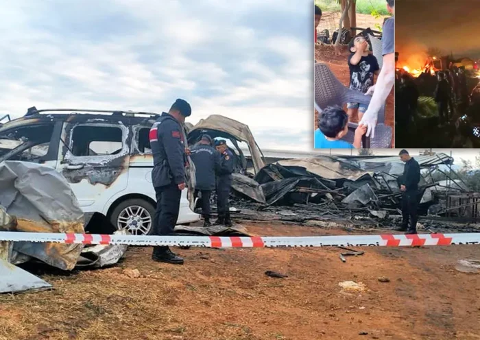 Turkish gendarmes inspect the scene of a fire next to the charred remains of a car and a container, with a photo of the dead children in one corner.