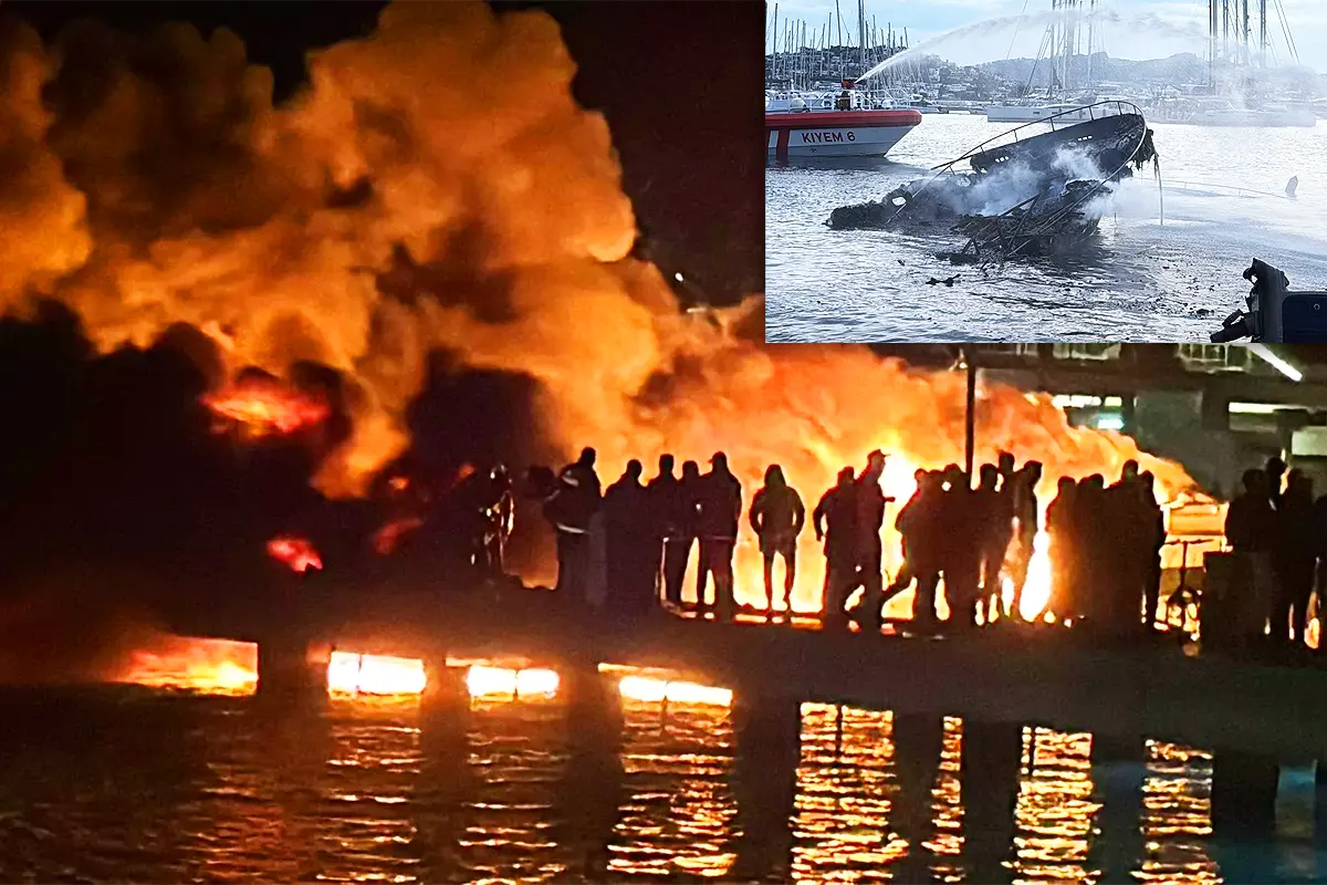 Several people look at a large fire at night in Bodrum marina, in one corner a daytime image of the harbour with a sunken yacht.