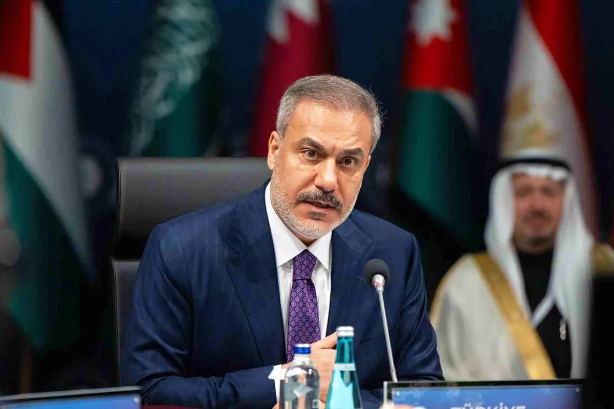 el ministro de exteriores de Turquía, Hakan Fidan, hablando en un foro con varias banderas árabes y líderes árabes de fondo