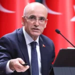 Turkish Minister Mehmet Şimşek with several Turkish flags in the background