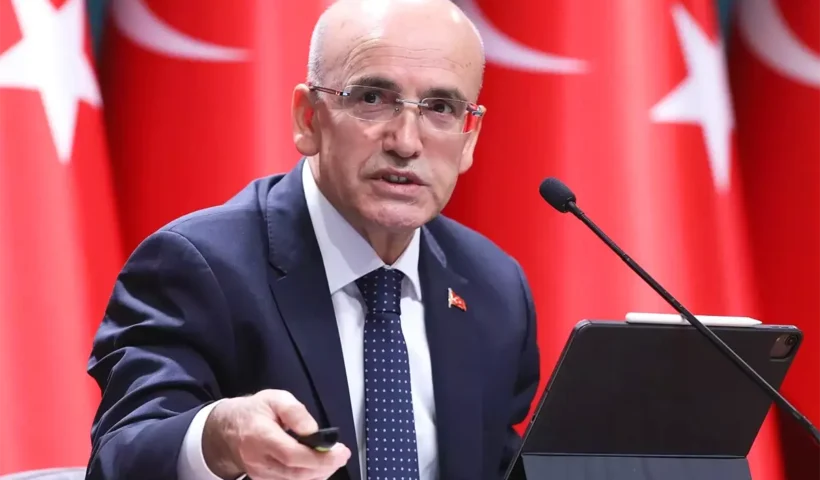 el ministro turco Mehmet Şimşek con varias banderas de Turquía de fondo