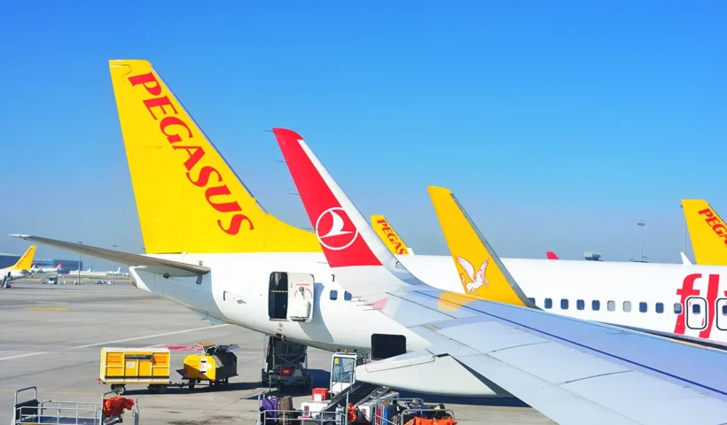 image of an airport runway showing the tail of a Pegasus aircraft and the wing of a Turkish Airlines aircraft