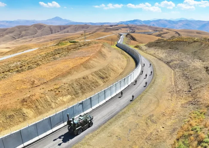 image of a large landscape on the Iran-Turkey border, with a border wall and Turkish patrols along the Turkish side of the border