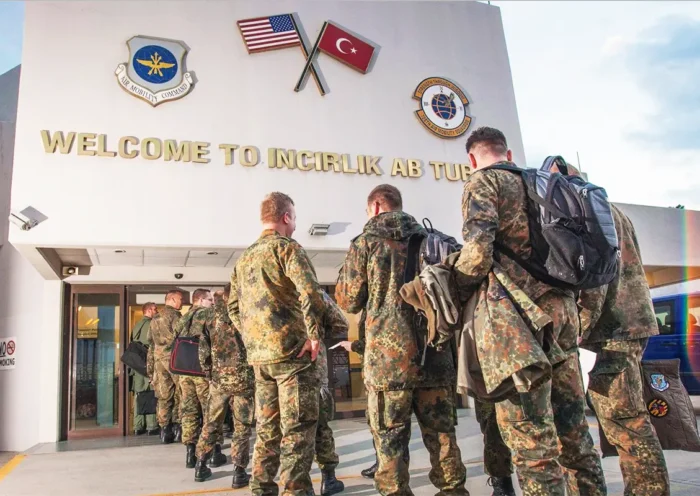 US soldiers queue at the entrance to Incirlik air base in Turkey, where the US and Turkish flags are displayed.