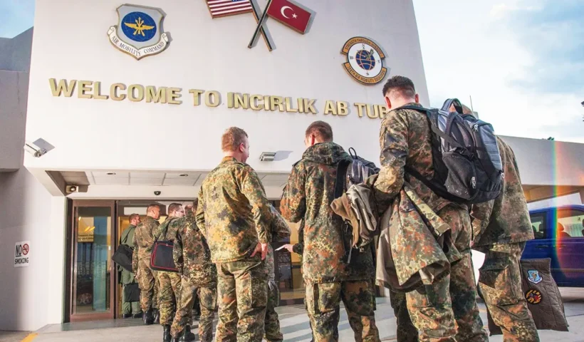 US soldiers queue at the entrance to Incirlik air base in Turkey, where the US and Turkish flags are displayed.
