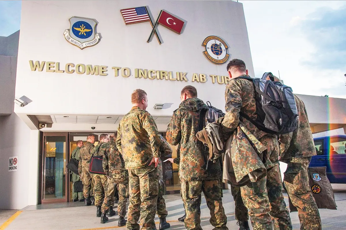 US soldiers queue at the entrance to Incirlik air base in Turkey, where the US and Turkish flags are displayed.