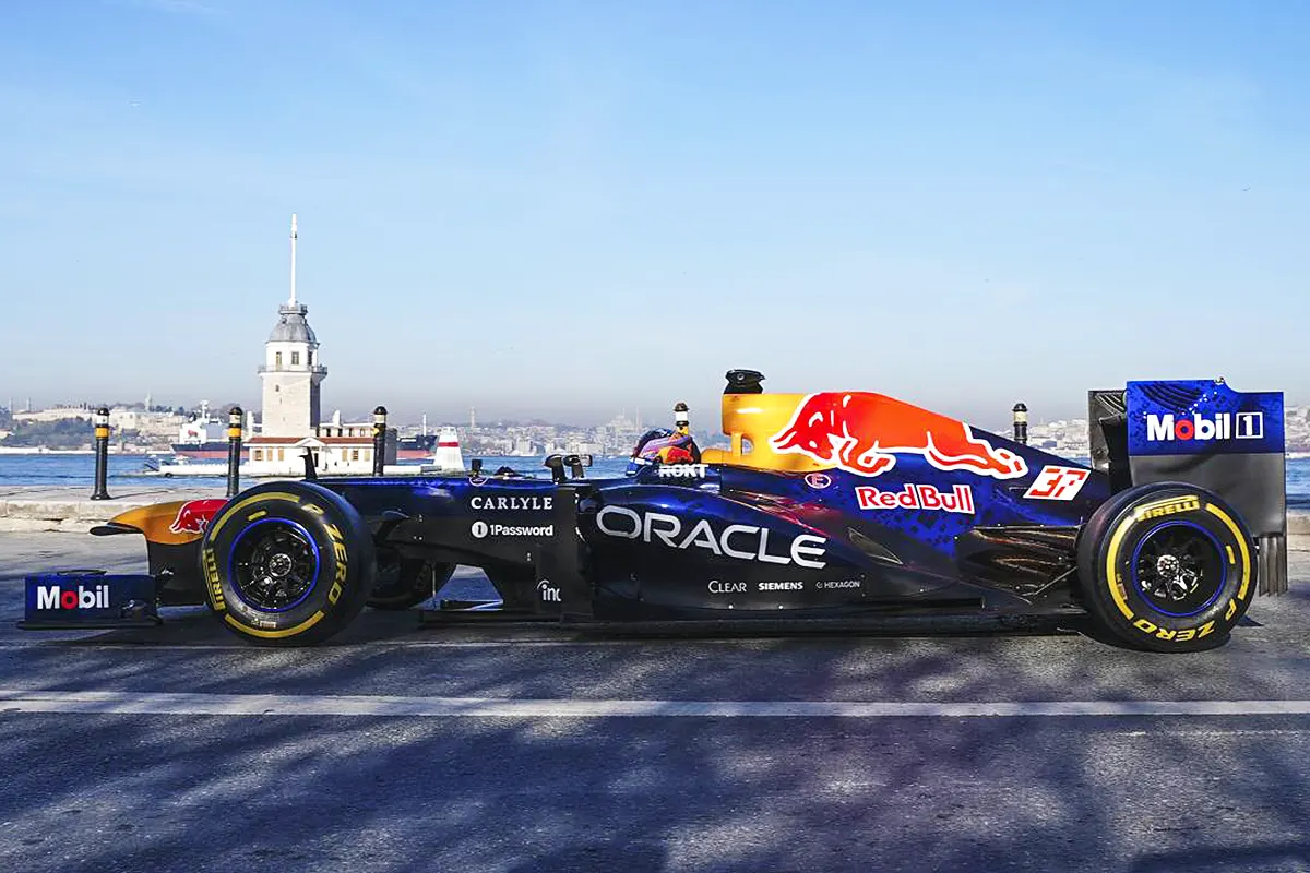 un coche de carreras de F1 con el logotipo de Red Bull en la costa de Estambul con la Torre de la Doncella al fondo