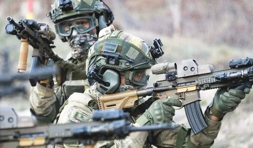 dos miembros de fuerzas de comandos del ejército turco portando armas y equipo militar en posición de combate