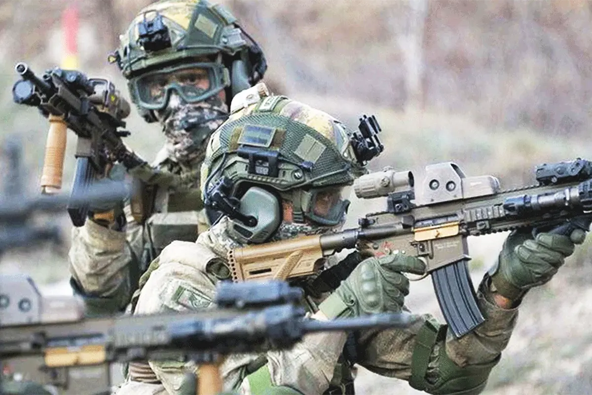 dos miembros de fuerzas de comandos del ejército turco portando armas y equipo militar en posición de combate
