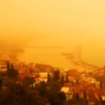 A bird's-eye view of Alanya Harbour in Antalya, with the air completely shrouded in an orange haze due to a dust storm
