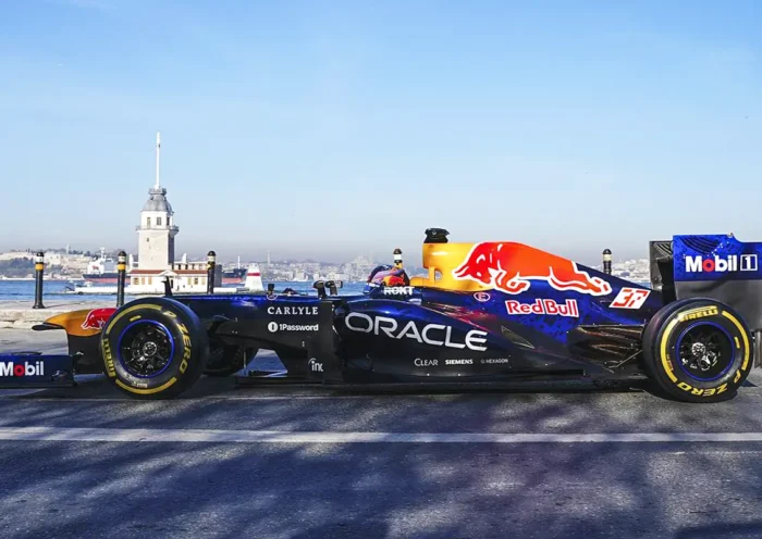 An F1 race car bearing the Red Bull logo on the Istanbul waterfront, with the Maiden's Tower in the background