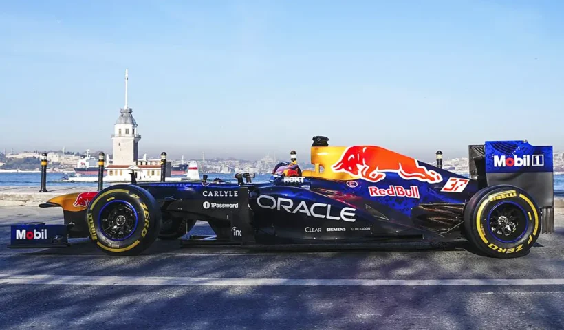 An F1 race car bearing the Red Bull logo on the Istanbul waterfront, with the Maiden's Tower in the background