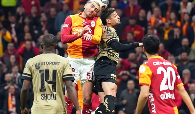Galatasaray and Kocaelispor players battle for the ball with their heads during a league match