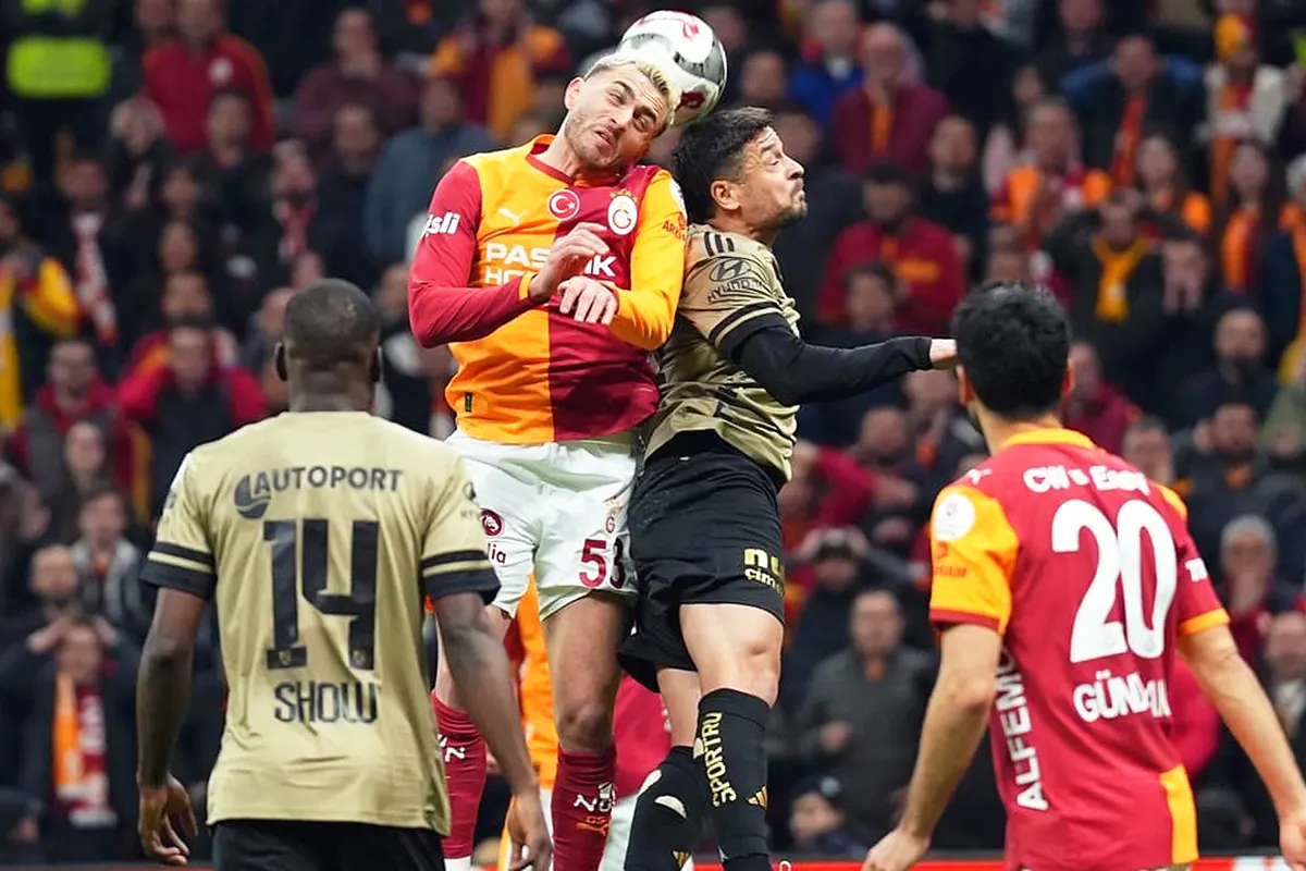 Galatasaray and Kocaelispor players battle for the ball with their heads during a league match