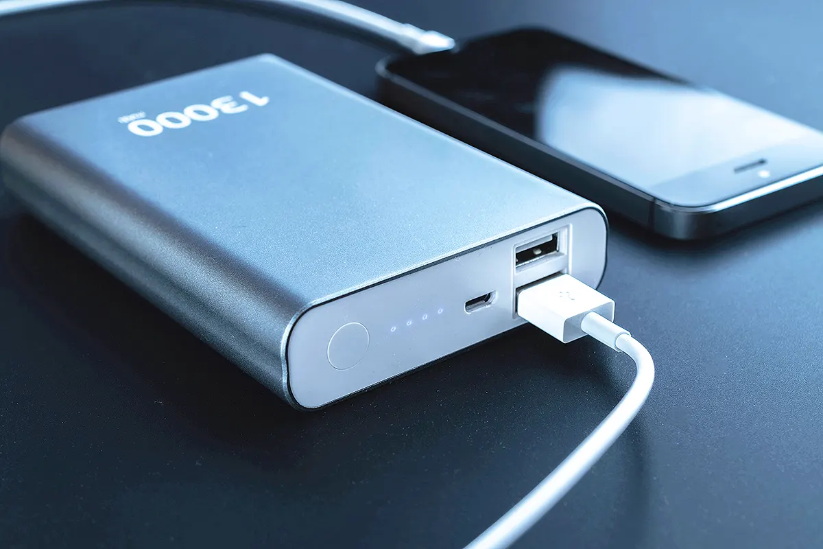 una powerbank o batería externa conectada mediante un cable a un teléfono móvil